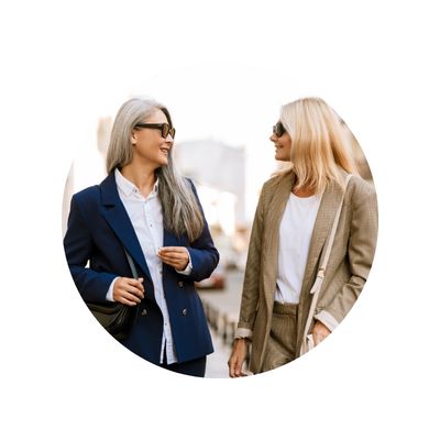 Two professional women wearing sunglasses, walking outside