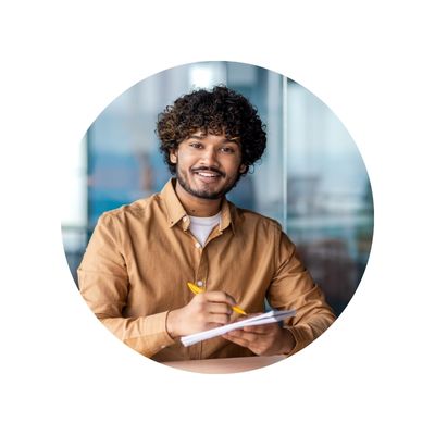 early career man taking notes and smiling