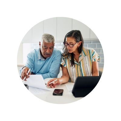 Mixed race senior couple going over paperwork with laptop opened