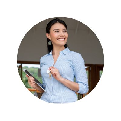 Smiling professional woman in blue collared shirt holding keys and a tablet computer