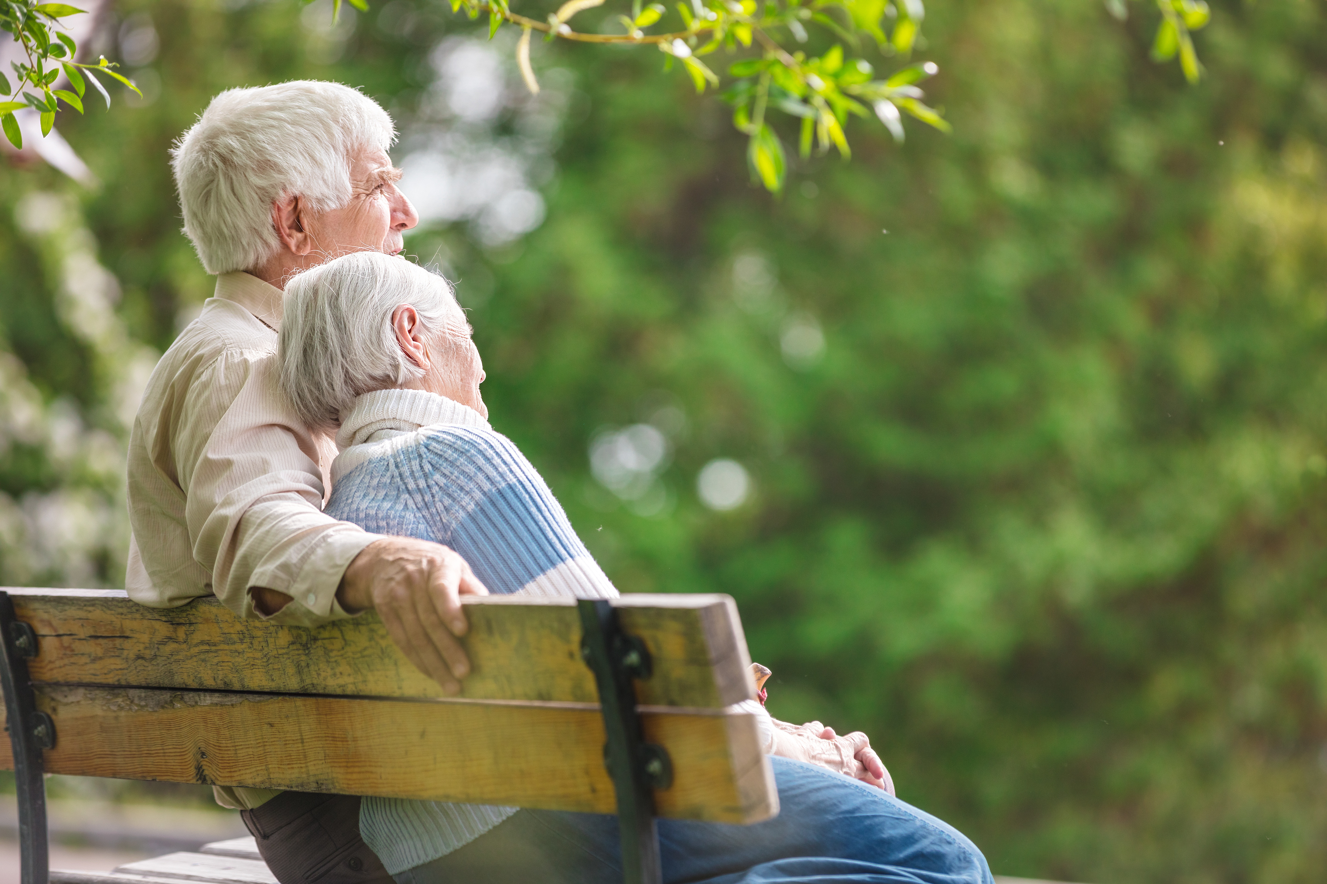 Elderly couple sitting on a bench enjoying retirement