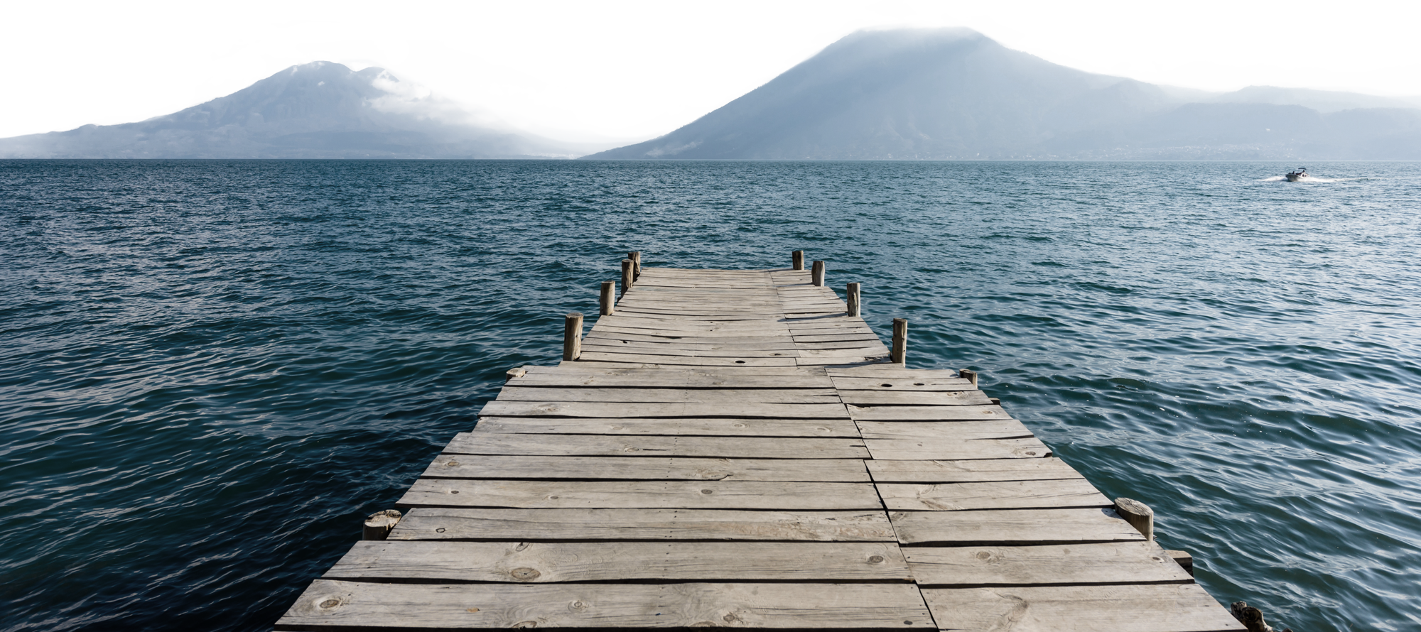 A long dock with blue waters in the background