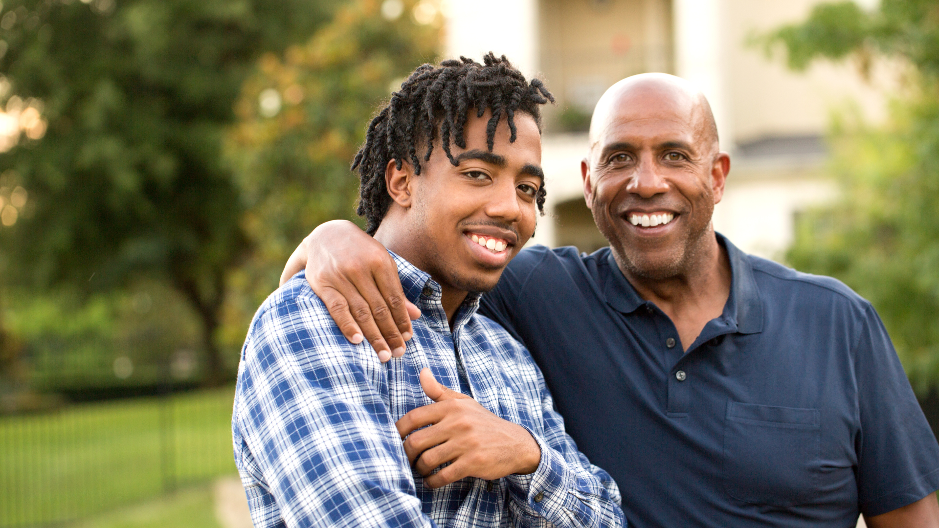 college grad son with father smiling and talking