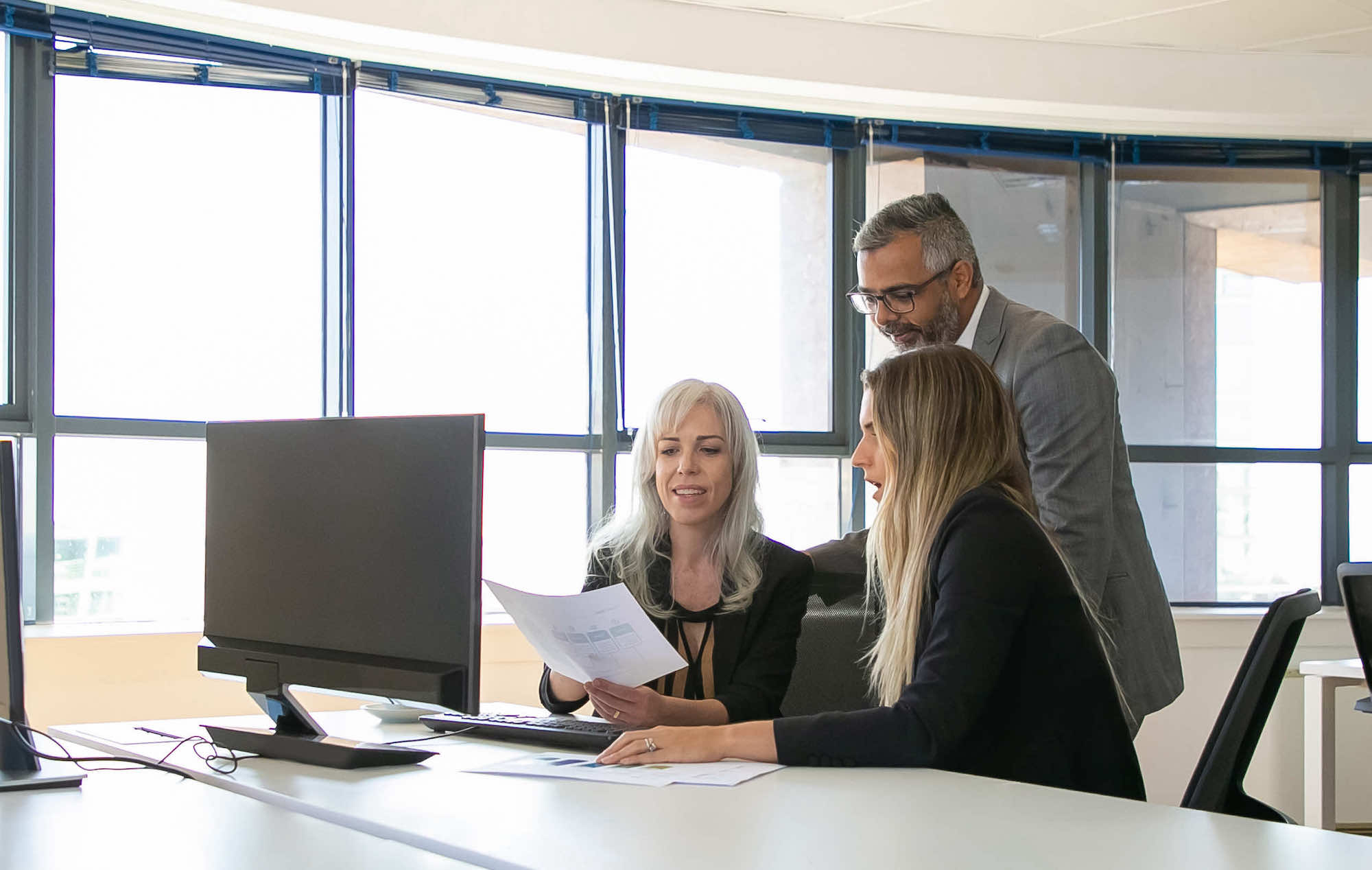 middle aged business man helping colleagues