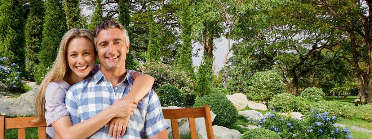 a smiling couple on a bench outside
